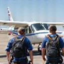 Two people geared up and boarding a plane
